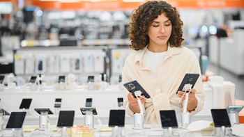 Ragazza sceglie quale smartphone acquistare in negozio